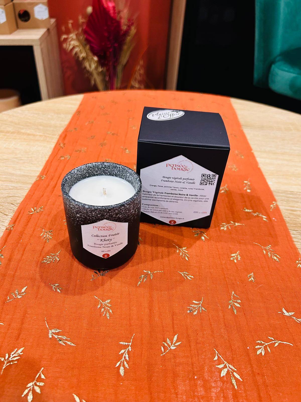 Bougie parfumée sur une nappe orange.