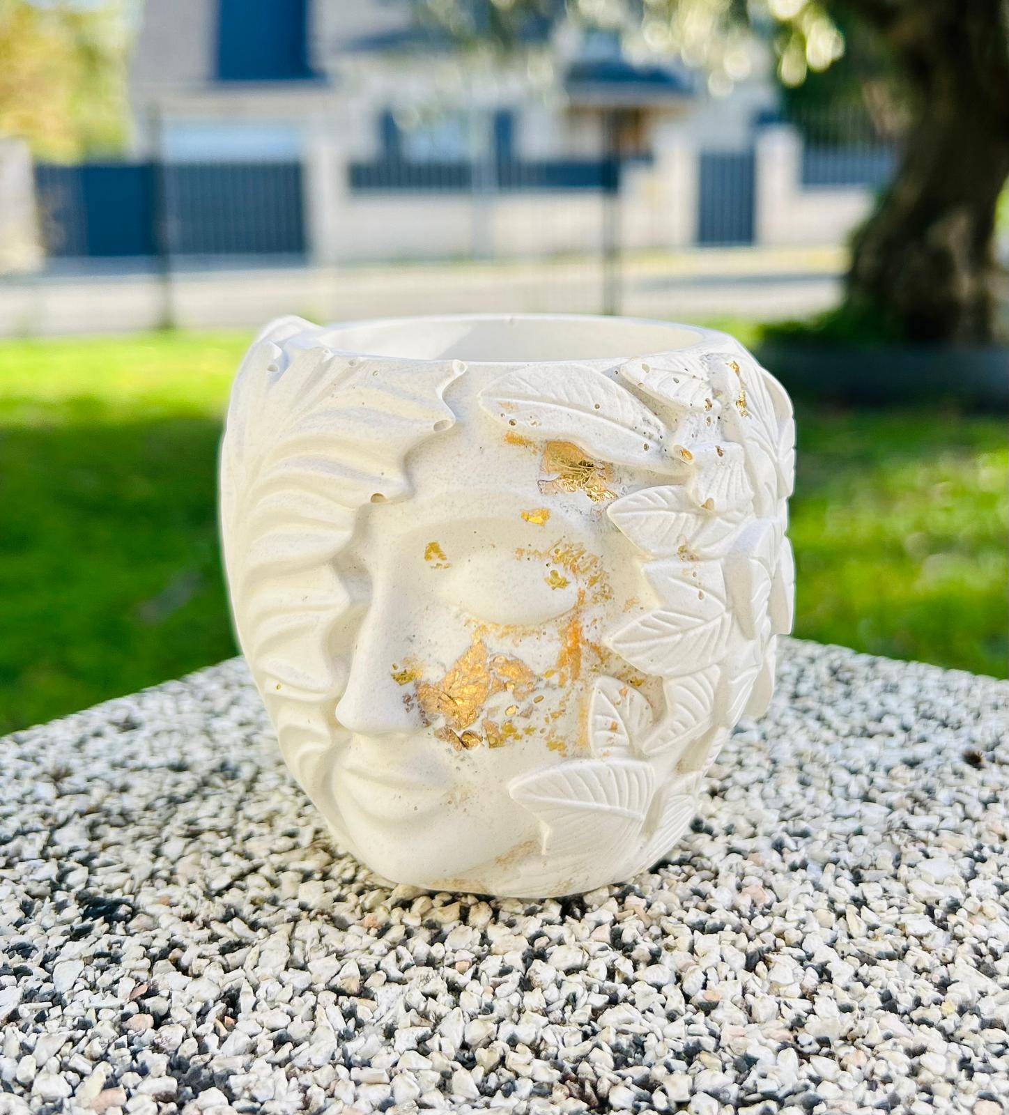 Vase décoratif en céramique blanche avec motifs.