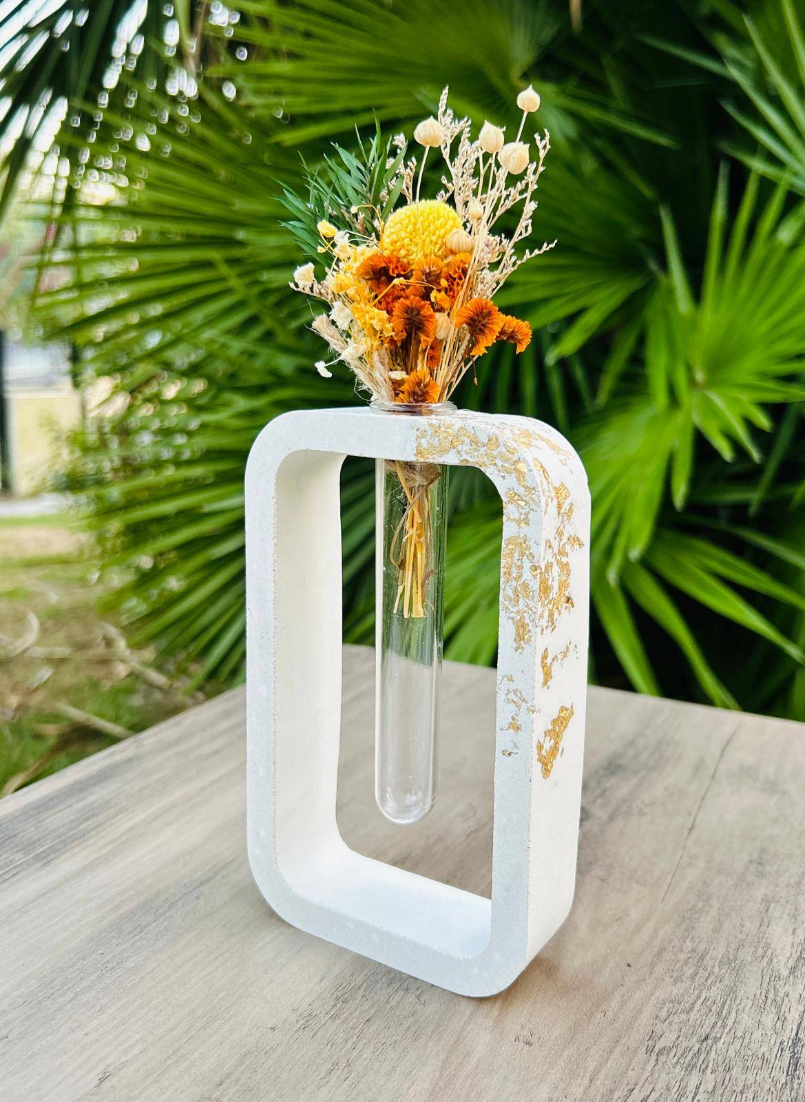 Vase moderne avec fleurs séchées colorées.