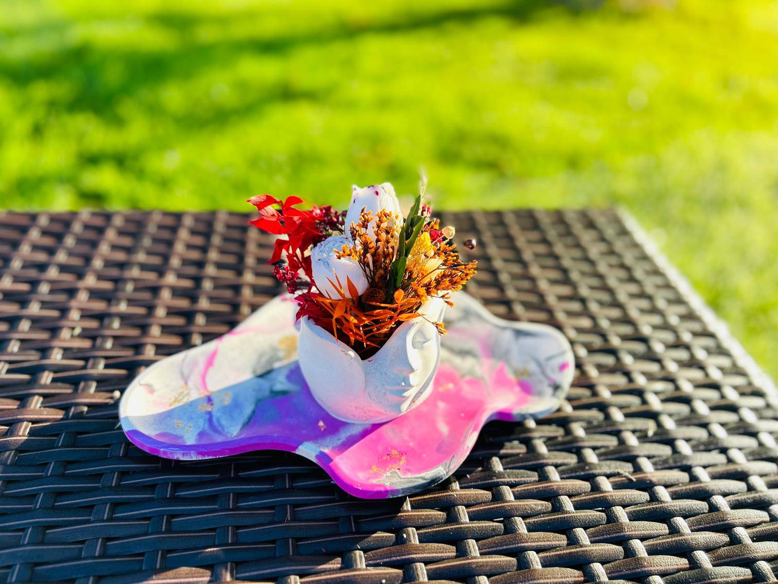 Vase avec fleurs colorées sur une surface en osier.