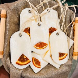 Étiquettes blanches avec des décorations d'orange séchée.