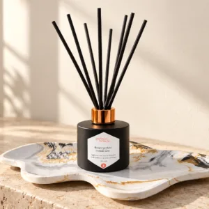 Diffuseur de parfum noir à bâtonnets sur plateau marbré