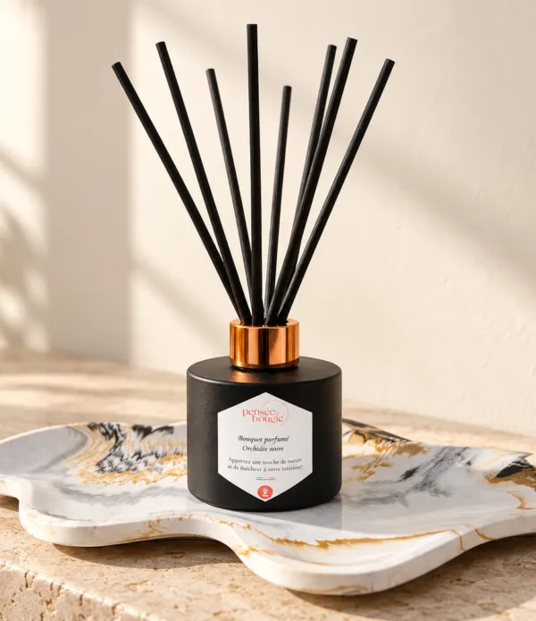 Diffuseur de parfum noir à bâtonnets sur plateau marbré
